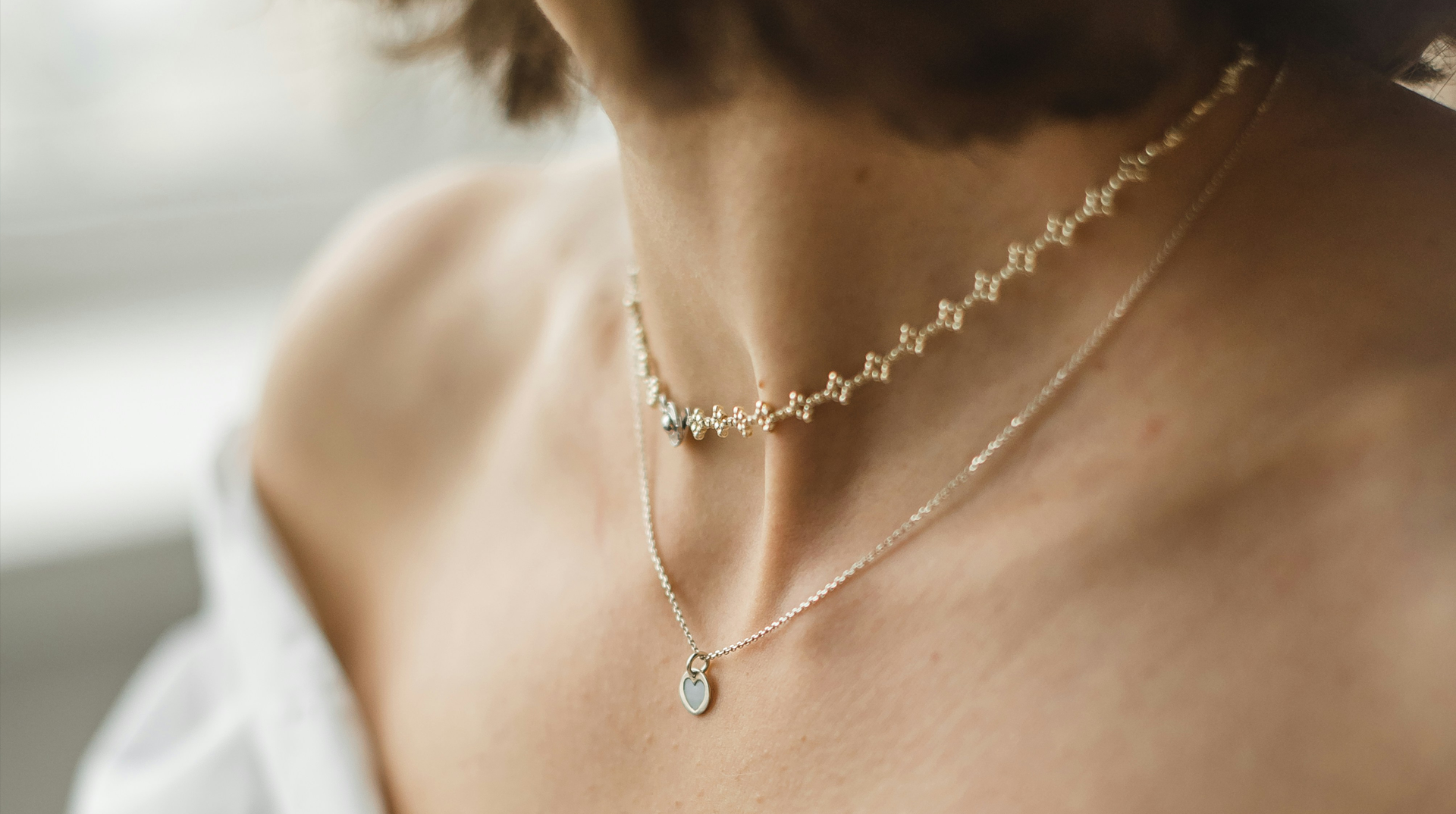 女性がゴールドのネックレスを2本付けている